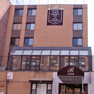 Exterior view of a multi-story residential building with a prominent entrance.