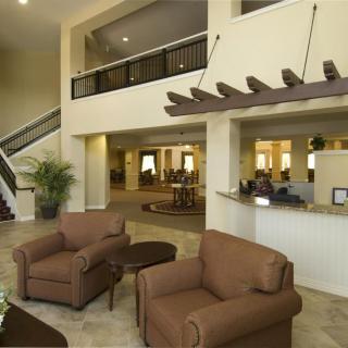 A spacious hotel lobby with seating area and reception desk.