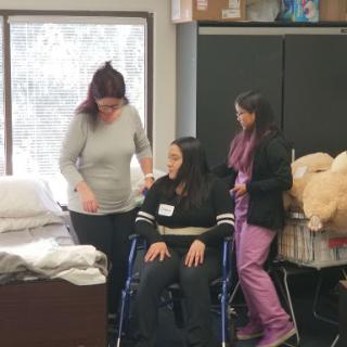 Students participating in a healthcare training session with assistive devices.