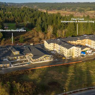 Aerial view of a retirement community surrounded by lush forests.