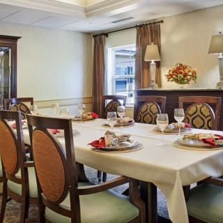 An elegantly decorated dining room with a set table and stylish chairs.