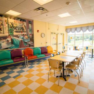 A retro-style diner interior with colorful seating and checkered floors.