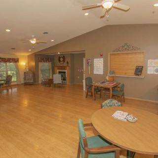Spacious living area with seating, tables, and a fireplace.
