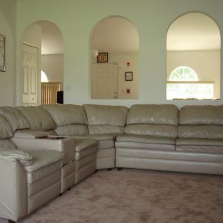 A spacious living room featuring a large sectional sofa with arched openings in the wall.