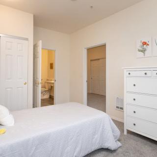 A bright and minimalistic bedroom with white furniture and bedding.