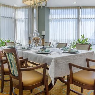 An elegantly set dining room table with chairs and decorative candles.