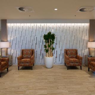 A well-lit lobby area with comfortable chairs and an indoor plant.
