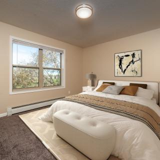 A modern bedroom with a large bed, stylish decor, and natural light from a window.