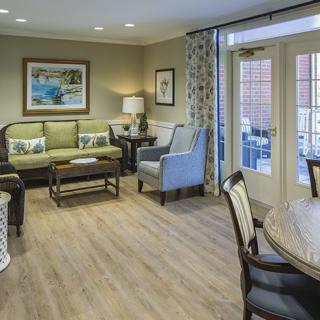 A stylish living room featuring a comfortable seating area, coffee table, and tasteful decor with artwork on the walls.