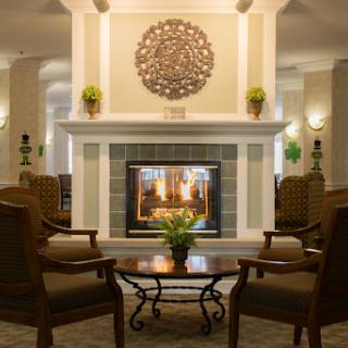 A cozy living room featuring a warm fireplace, comfortable seating, and elegant decor.
