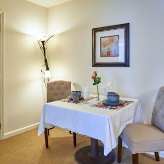 A cozy dining area featuring a neatly set table with decorative elements, perfect for intimate meals.