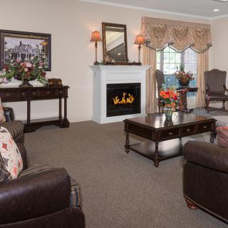 A traditional living room with a cozy fireplace and elegant furnishings.