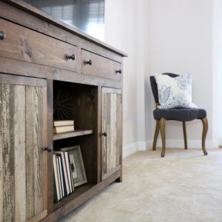 A cozy living room corner featuring a rustic cabinet and an elegant chair.