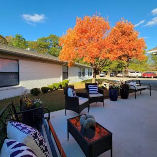A cozy outdoor patio adorned with autumn foliage, perfect for enjoying the crisp fall air.