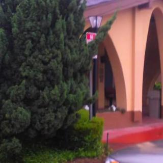 A building with arched architecture surrounded by greenery.