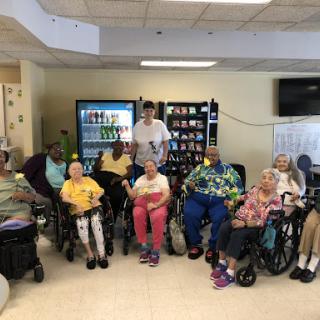 A group of elderly residents enjoying a social moment together in a recreational area.