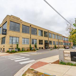 A modern brick industrial building located on an urban street corner.