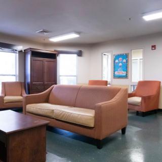 A cozy waiting room with sofas and chairs arranged for seating.