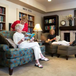 Three people enjoying a quiet reading session in a cozy living room.
