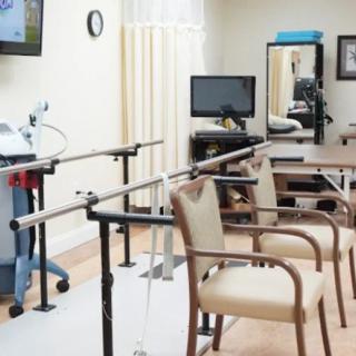 A rehabilitation clinic equipped with parallel bars and seating for physical therapy sessions.