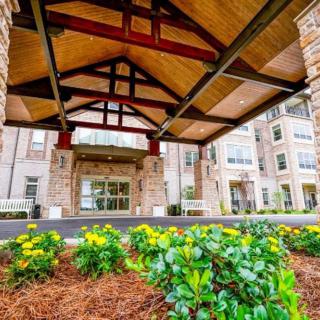 A well-landscaped entrance of a modern building adorned with flowers and greenery.