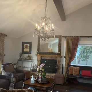 A cozy living room with a chandelier, fireplace, and elegant decor.