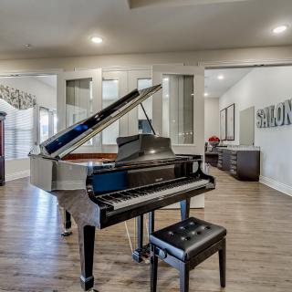 A stylish living room featuring a grand piano on a wooden floor.