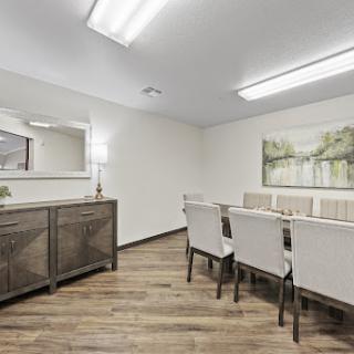 A spacious and modern dining room featuring elegant furniture and warm lighting.
