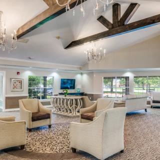 A spacious and elegantly designed lobby with comfortable seating, chandeliers, and exposed beams.