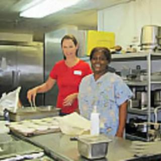 Two people working together in a kitchen.