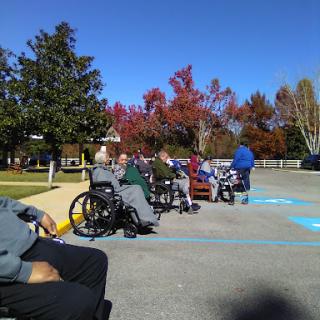 Residents enjoying a sunny autumn day outdoors in wheelchairs.