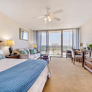 A modern and spacious bedroom with a large window view and balcony access.