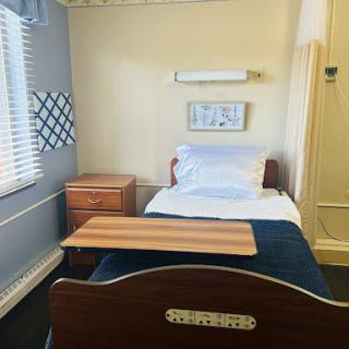 A cozy, well-lit bedroom featuring a single bed and wooden furniture.