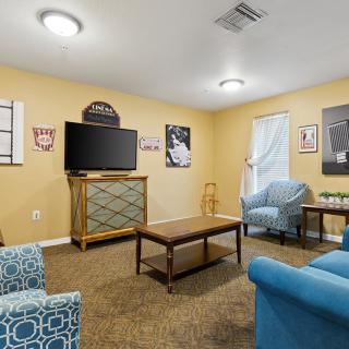 A cozy living room area with modern furniture and a wall-mounted television.