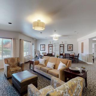 A spacious and well-lit living room with comfortable seating and elegant decor.