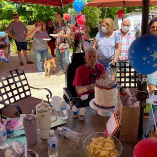 A joyful gathering celebrating a birthday with friends and family outdoors.