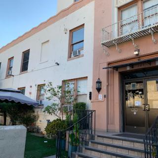A charming entrance to a residential building with decorative elements and greenery.