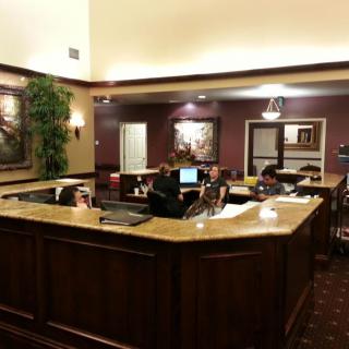 A reception area with a wooden desk and computers in a well-decorated office lobby.