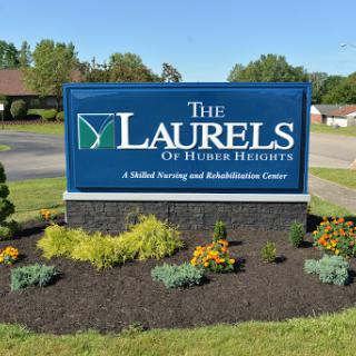 Sign for The Laurels of Hudson Heights, a skilled nursing and rehabilitation center, surrounded by landscaped gardens.