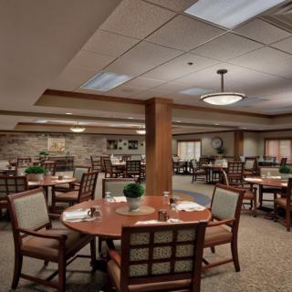 A well-decorated dining area with multiple tables and comfortable seating, featuring ambient lighting and tasteful decor.