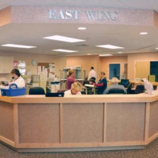 A busy nurse station in a hospital with medical staff performing various duties.