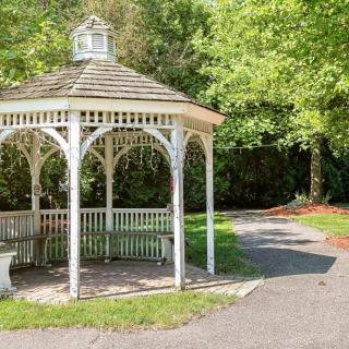 A quaint gazebo nestled in a lush, green park setting.