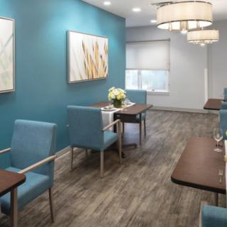 A modern waiting room with blue walls, stylish lighting, and comfortable seating.