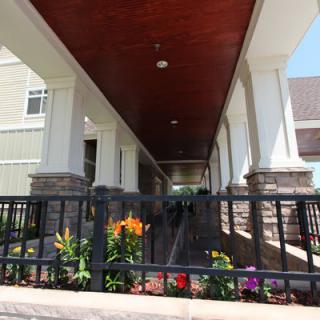 A view of a building entrance with a ramp and flowerbed.