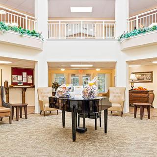 A spacious lobby featuring a grand piano and comfortable seating.
