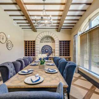 Elegant dining room with a large wooden table, plush chairs, and decorative place settings.
