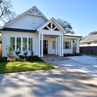 A charming modern house with a well-maintained front yard and spacious driveway.