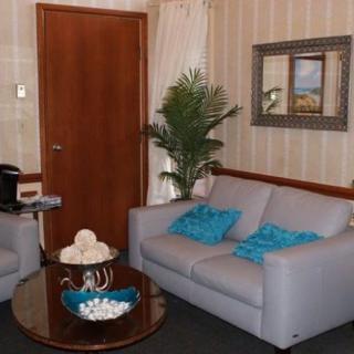 A cozy living room with a gray sofa adorned with teal cushions, complemented by a small round table and decorative elements.