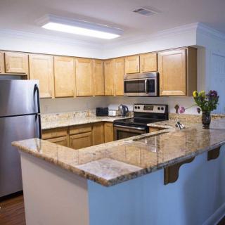 A modern kitchen with wooden cabinets and stainless steel appliances.