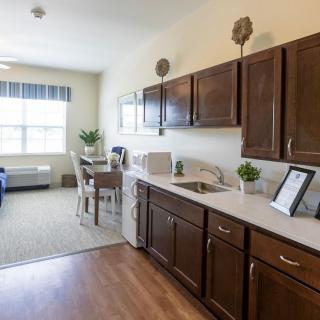 A modern kitchen and dining area with dark wood cabinets and contemporary furnishings.